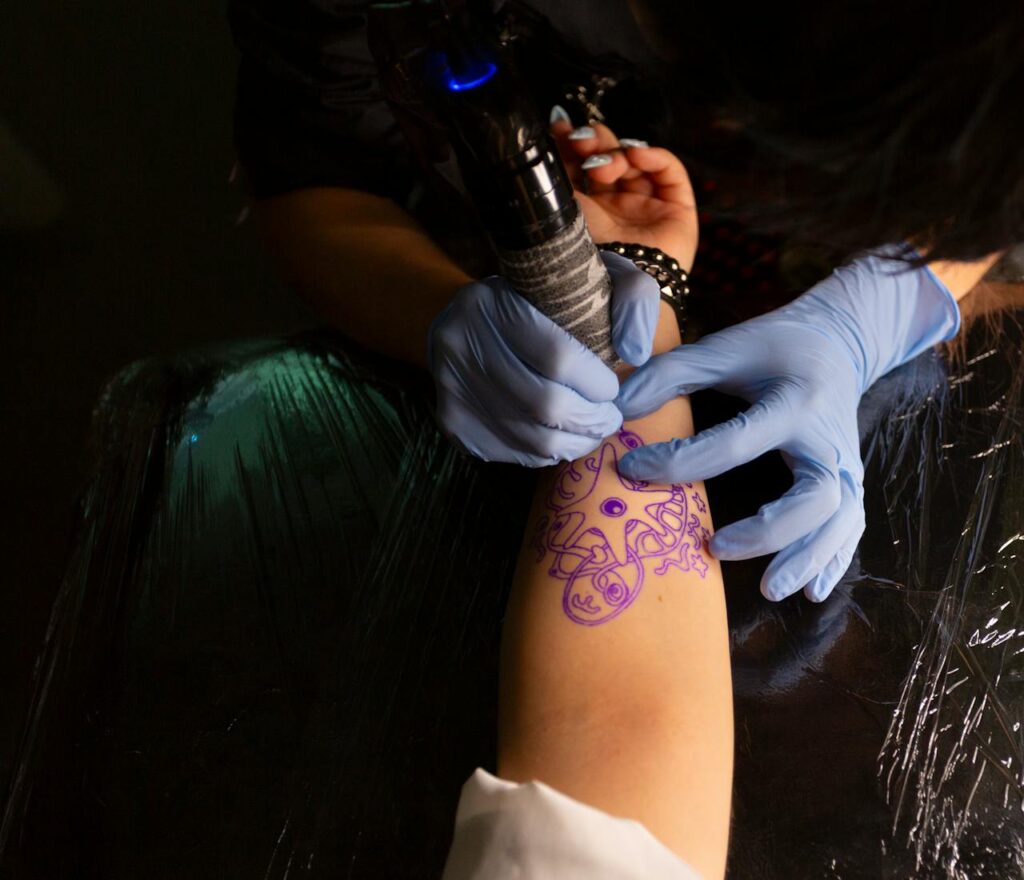 A tattoo artist works on a tribal arm design in a Tokyo tattoo studio, showcasing skill and precision.
