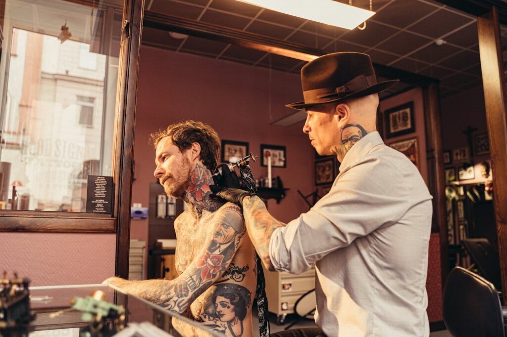 A tattoo artist skillfully working on a client's back in a vintage-style tattoo studio.